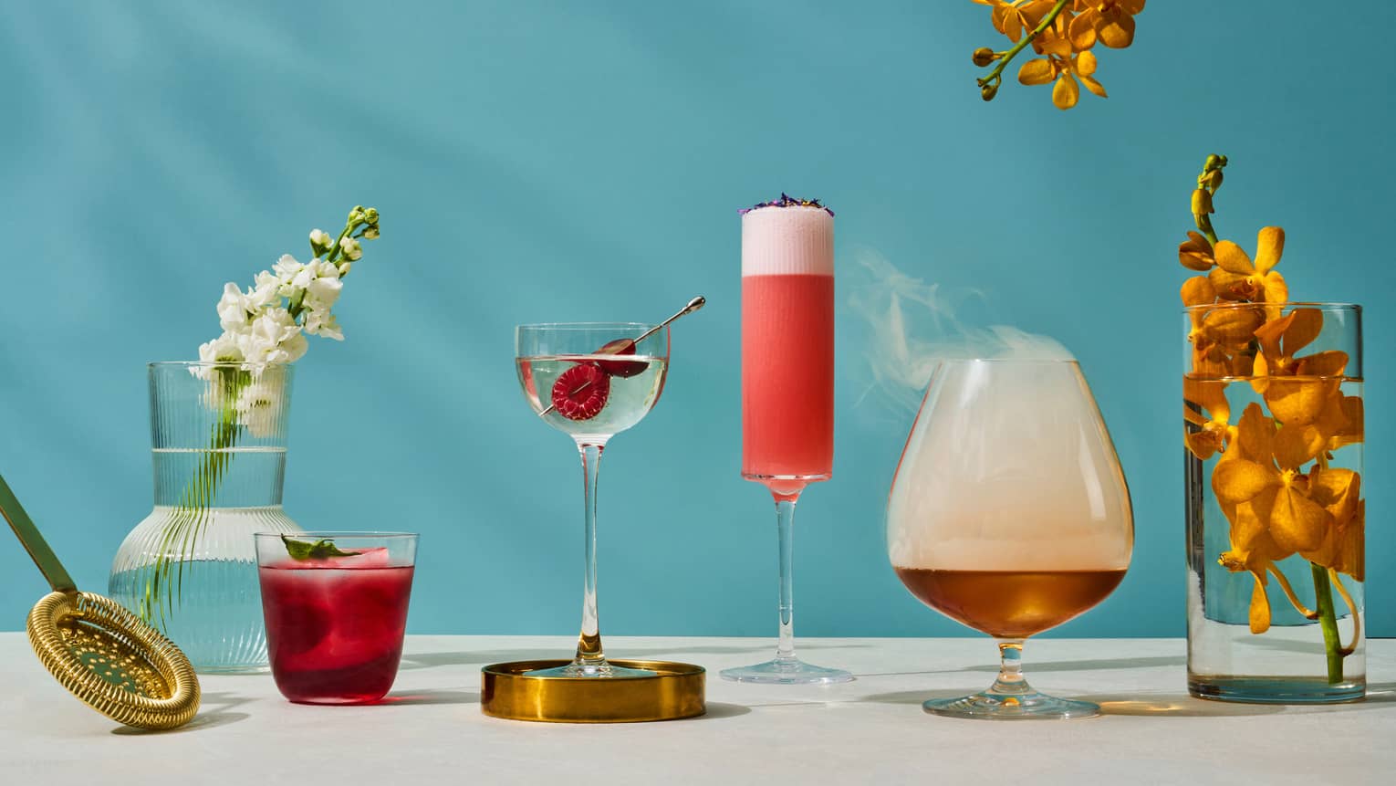 Assorted summer cocktails available at One-Ninety Bar with blue background