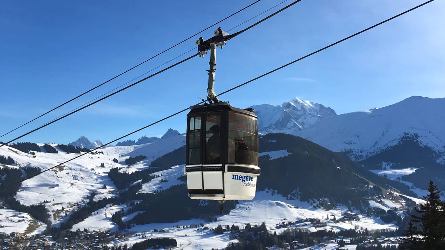 Cable car with snowy French Alps and blue sky in backdrop