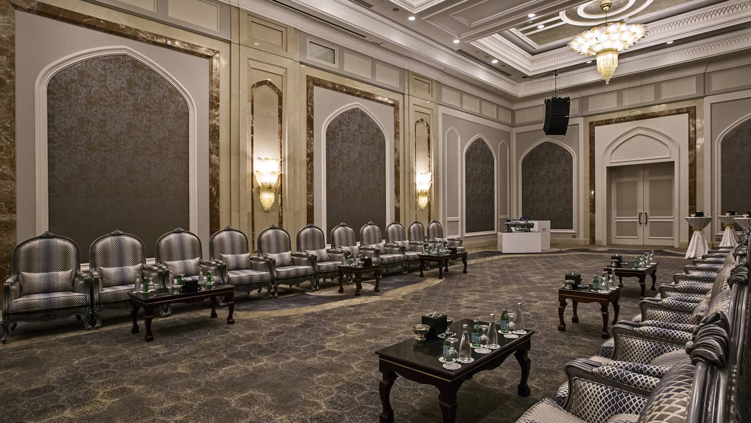 Elegant armchairs, tables with water lines sides of event ballroom
