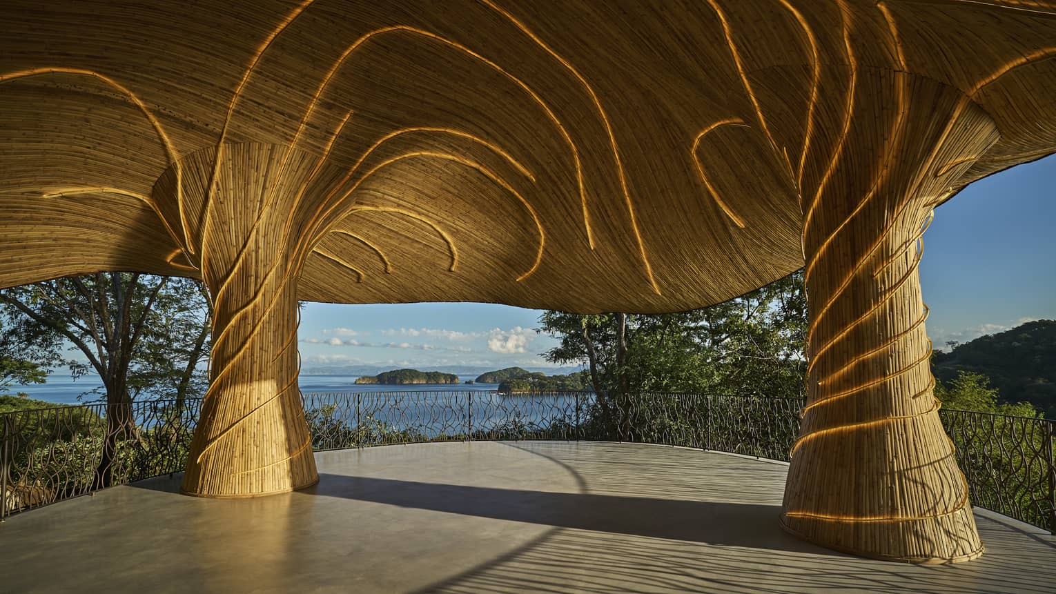 Outdoor shala with a organic and fungal-like roof structure overlooking the ocean