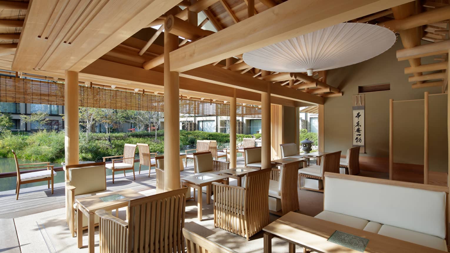 Shakusui-tei sunny patio with wood chairs, tables under white paper umbrella