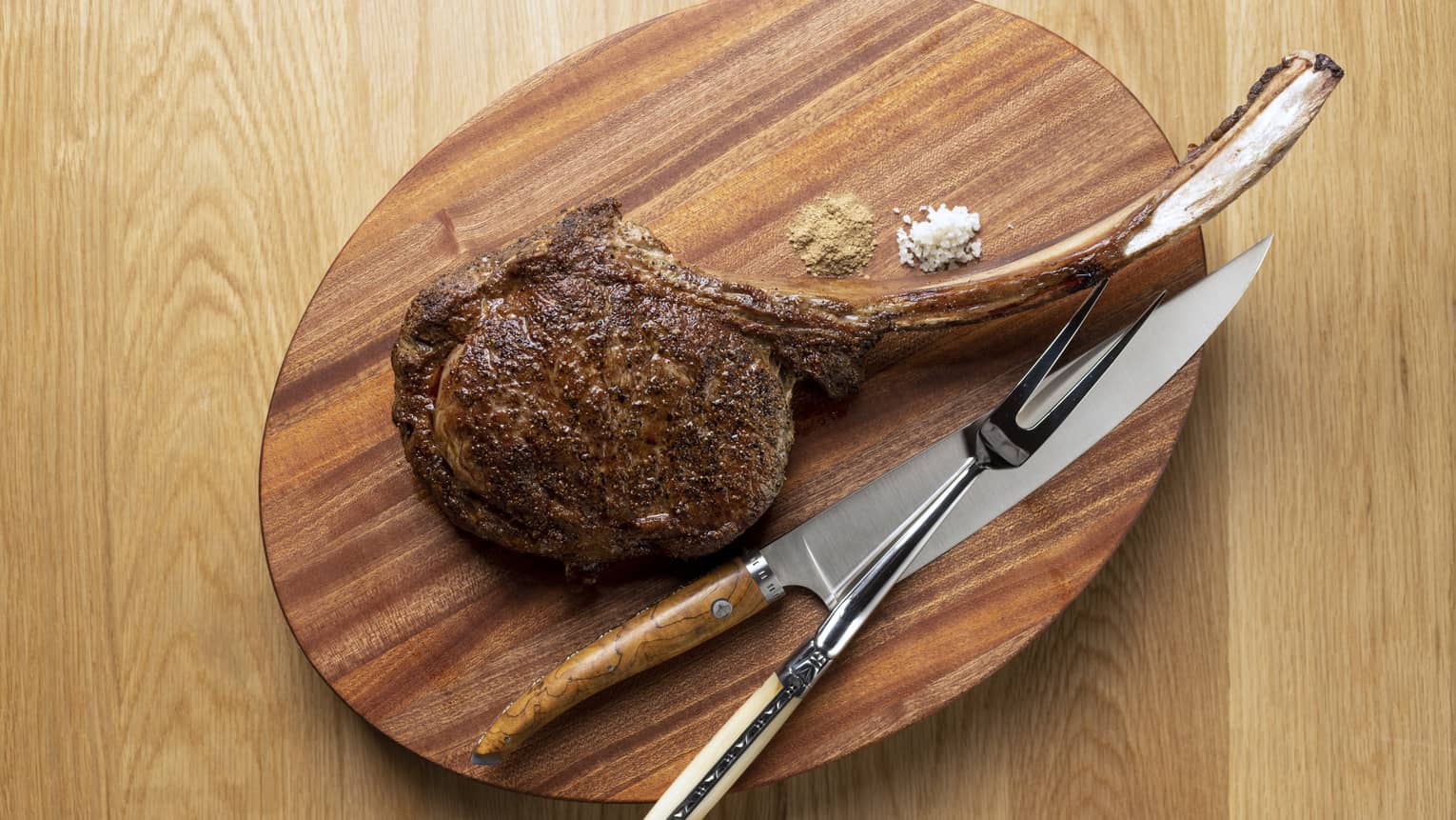 Tomahawk steak on wooden oval carving board