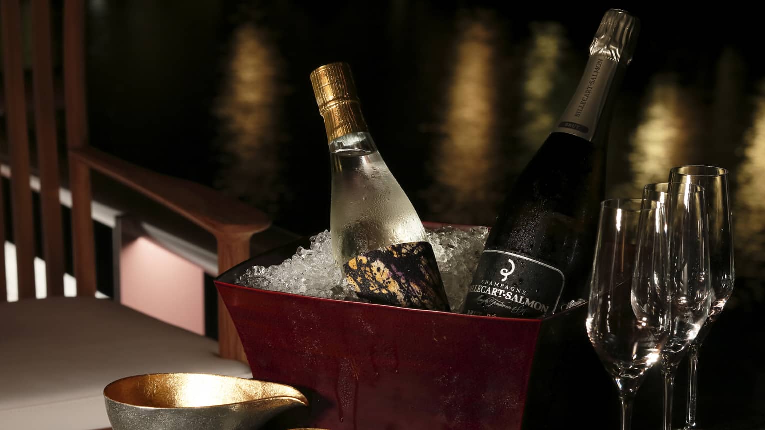Bottles of sake and Champagne in brown ice bucket on table with glasses