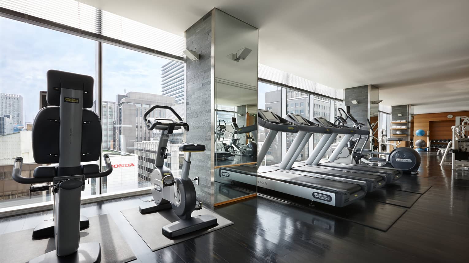 Elliptical machines, treadmills, cardio equipment by sunny window in Fitness Centre