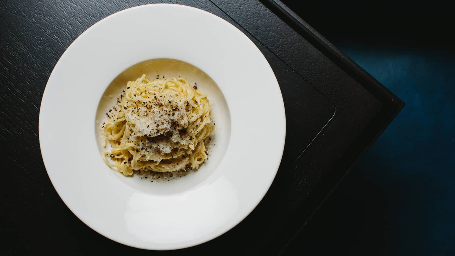 Seasoned tagliolini pasta on plate.