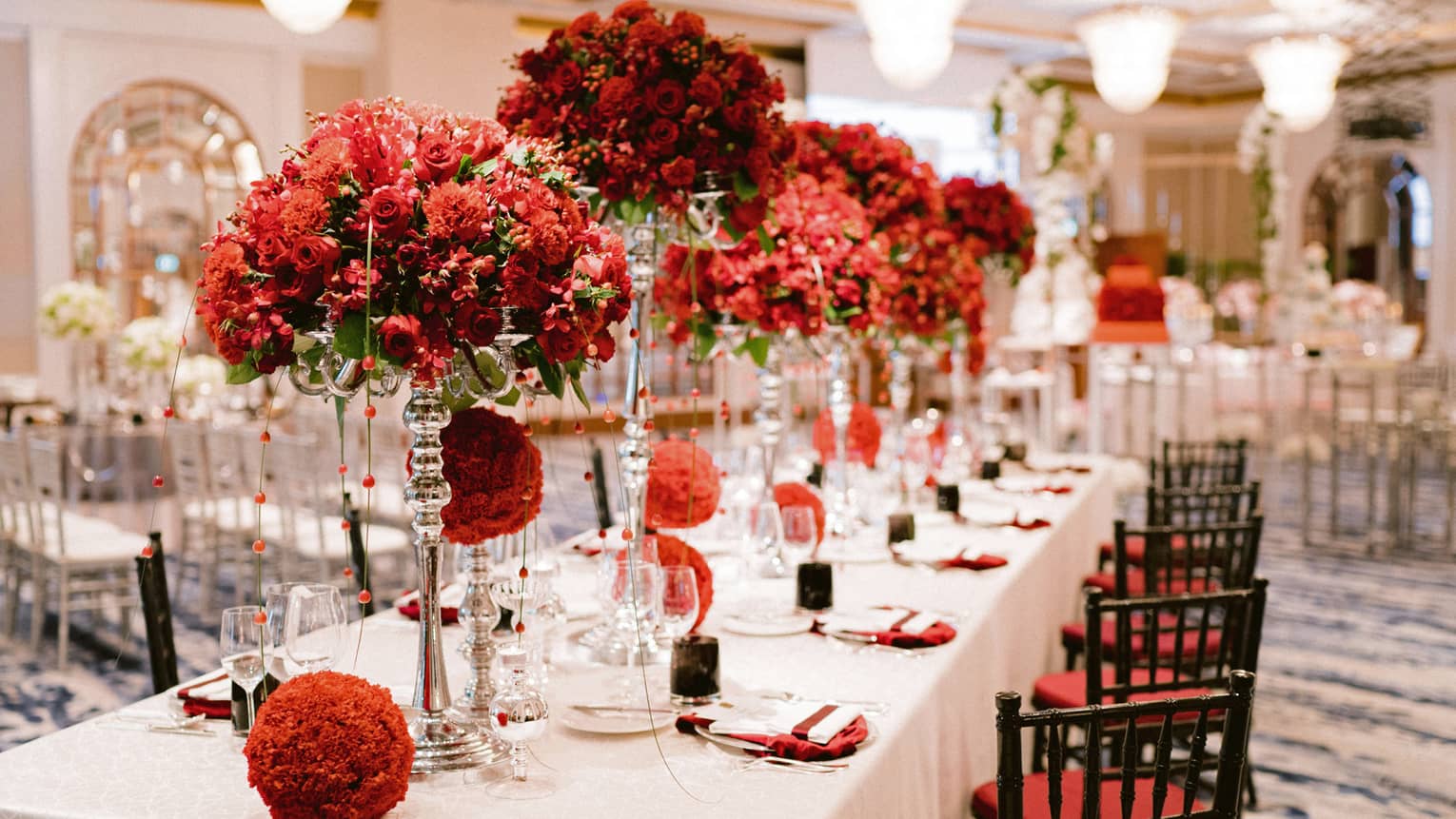 Red flower arrangements on dining table in wedding reception banquet room