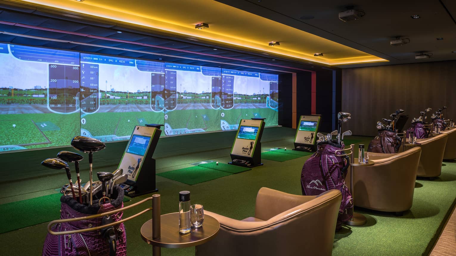 Wall with animated screens, 3D golf course game centre, armchairs with water bottles