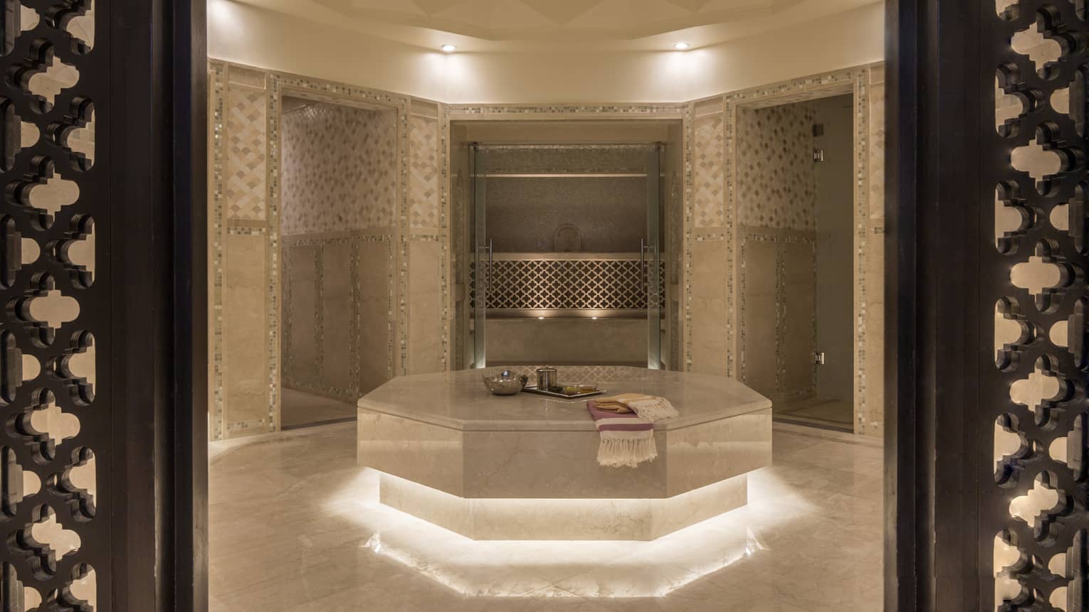 Hammam room with illuminated under lighting, beige marble