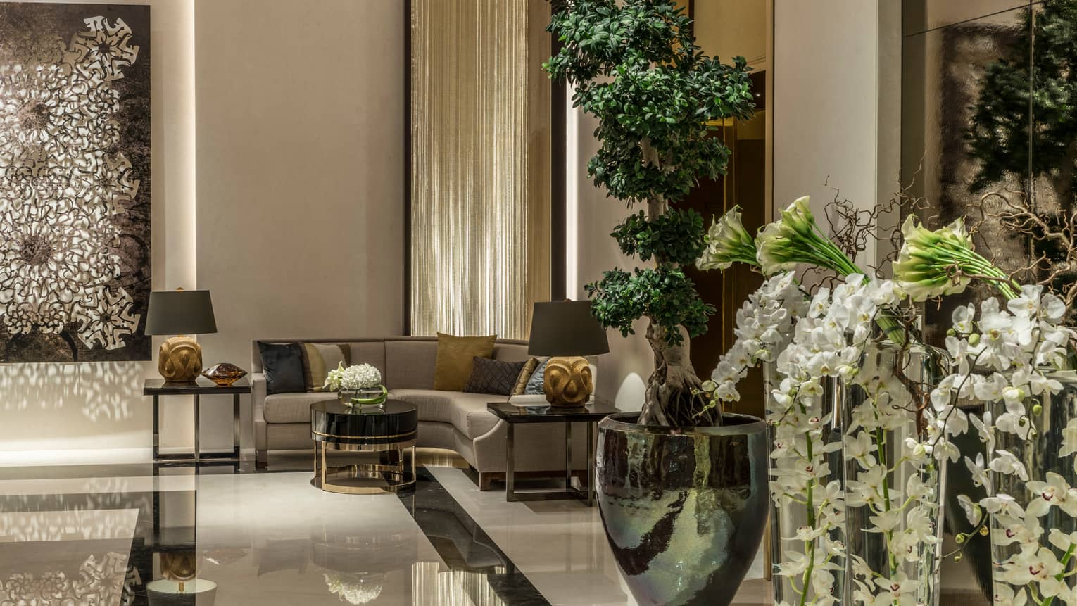 Lobby with curved corner sofa, large vases with fresh flowers, Arabic decor