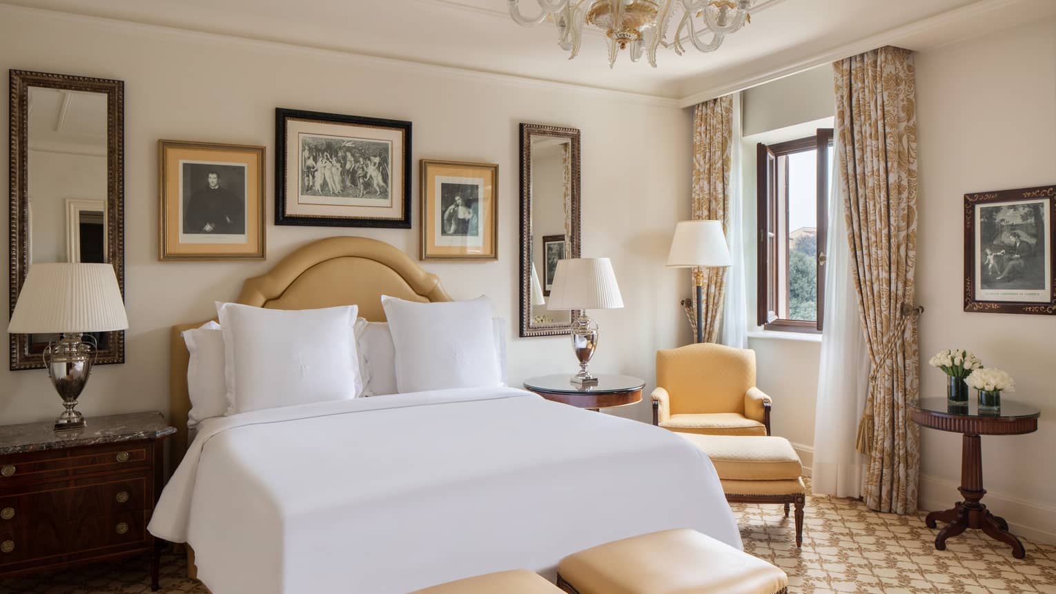 Four Seasons Room at Four Seasons Hotel Firenze, with soft-yellow furniture, framed art, lamps and tree view through window