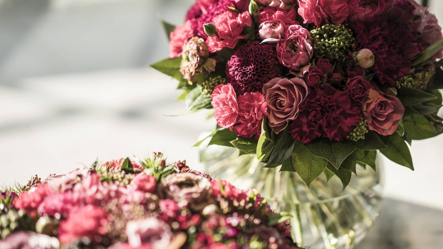Closeup of two mauve and red floral bouquets in vases