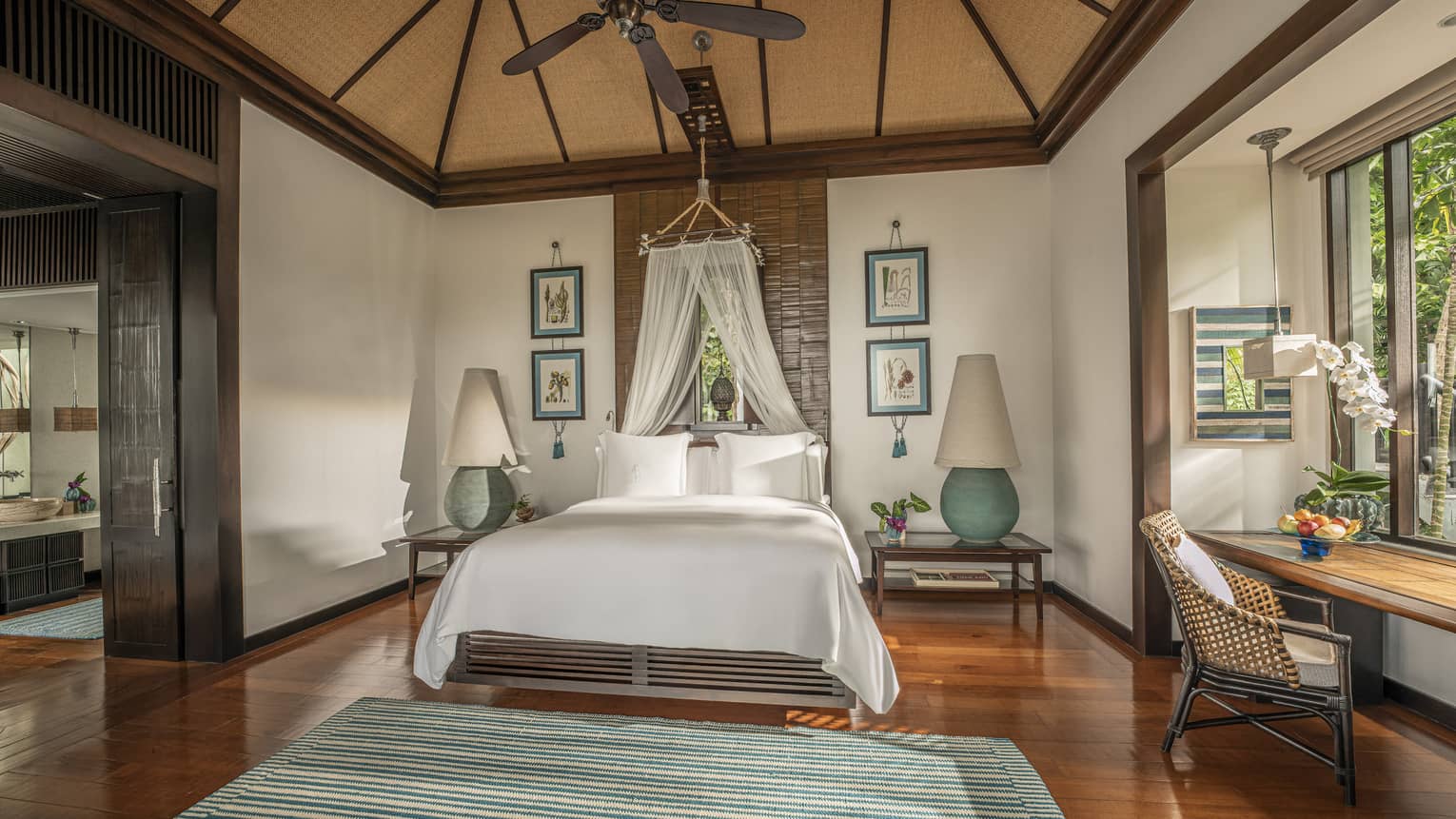 Master bedroom with teak floors, king bed with canopy net, vaulted ceiling and ceiling fan
