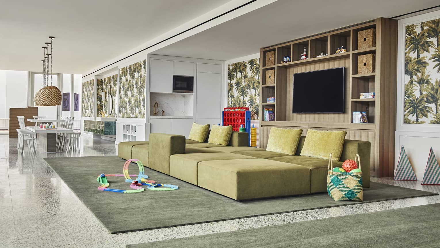 Bright kids facility with craft table, large sofa, toys and games. Specially-trained staff entertain children