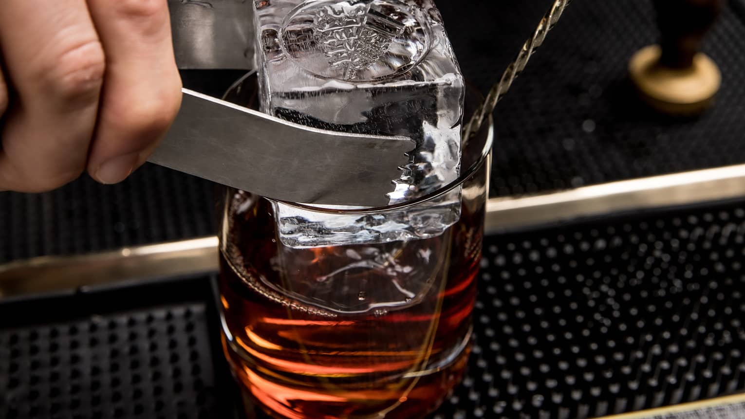 ,A drink with a large ice cube being dropped in.