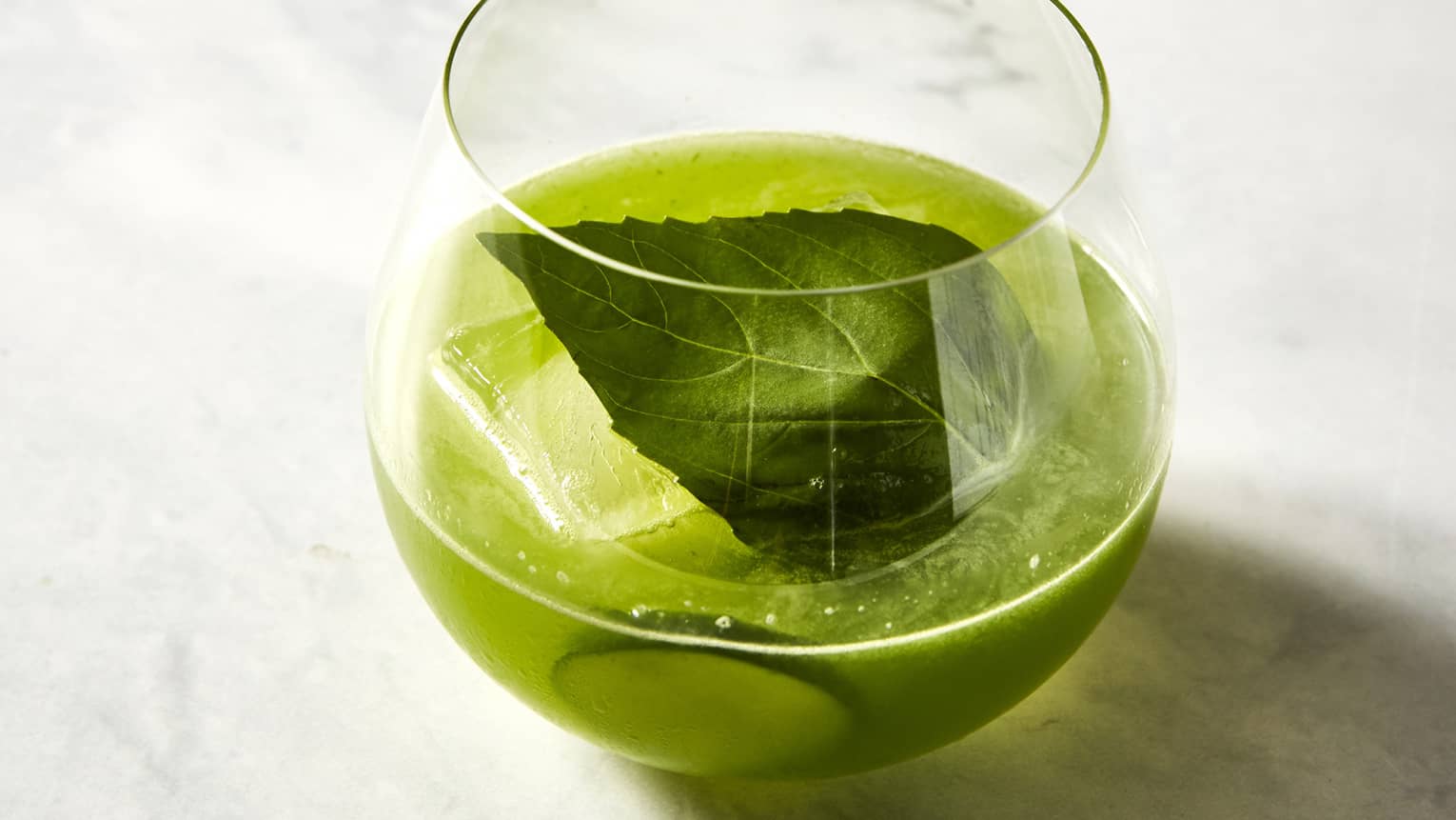 A green beverage with mint and lime. 