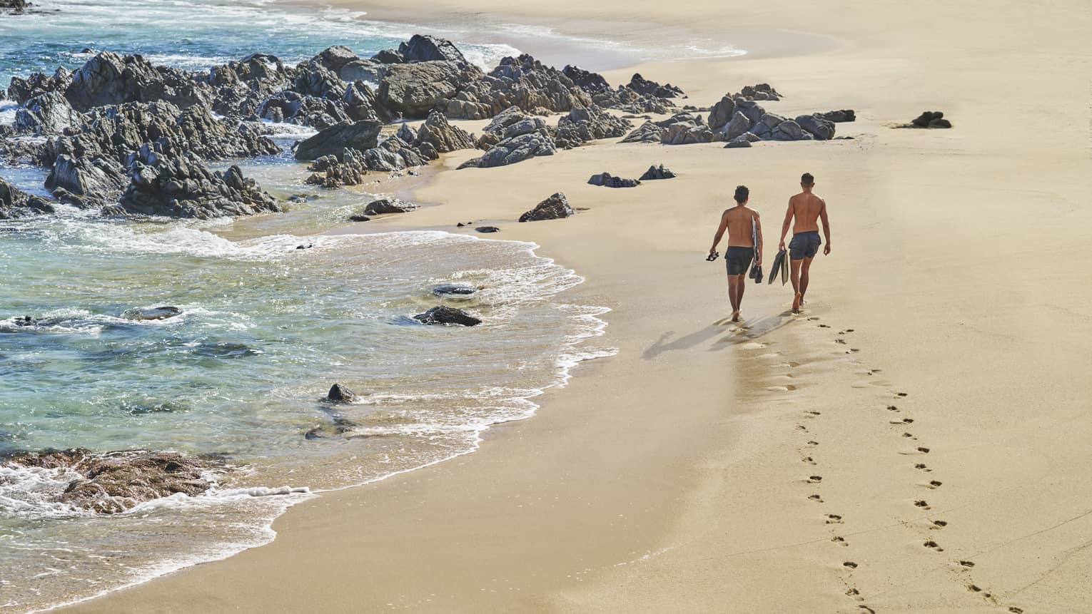 Two people walking on a sandy beach