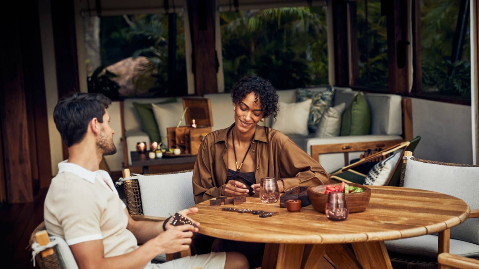 A man and woman sitting at a round table in a luxury tent.