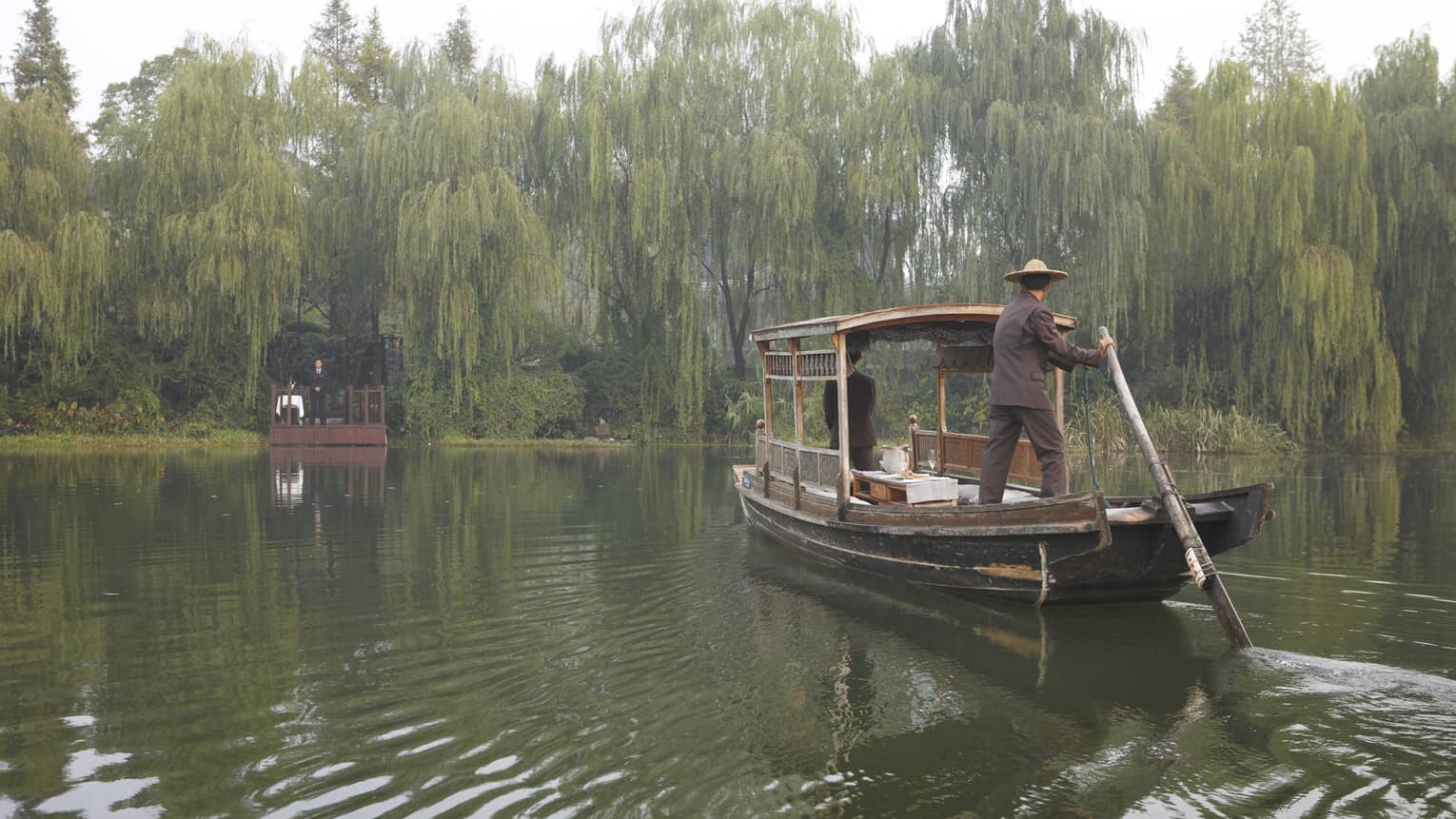 A guest arriving at a dock in Hangzhou, surrounded by weeping willows