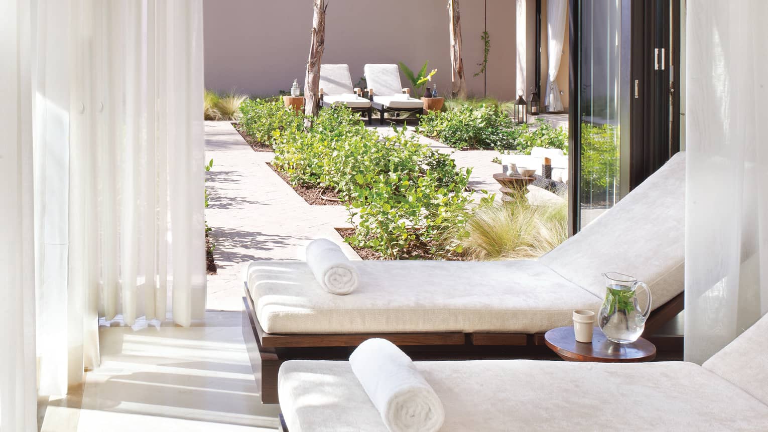Two white lounge chairs in cabana on spa patio