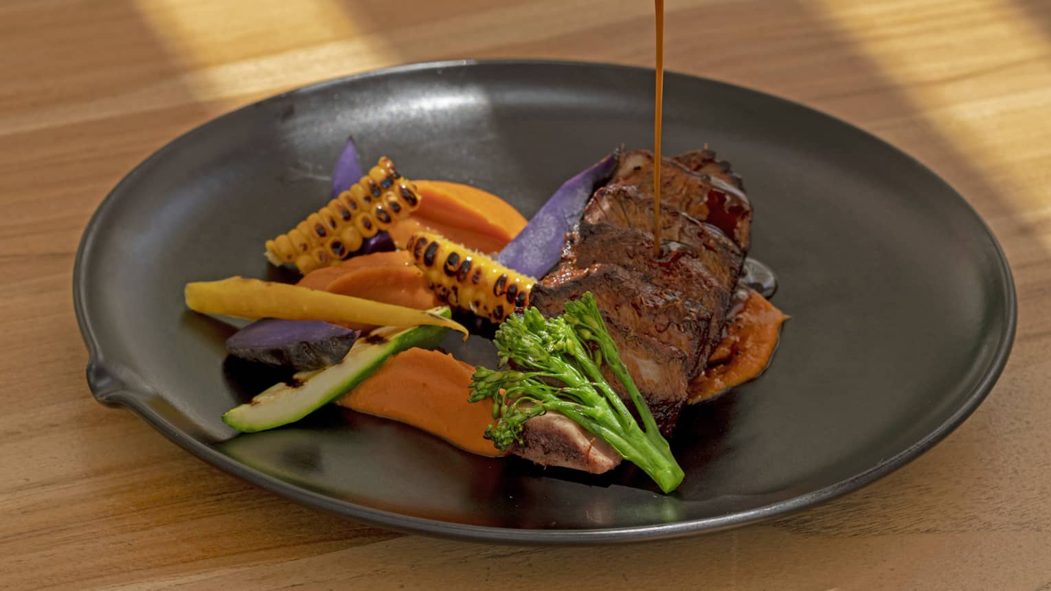 Slow-Cooked Creekstone Beef Short Rib, Sweet Potato Mash, Tequila Glaze being poured over