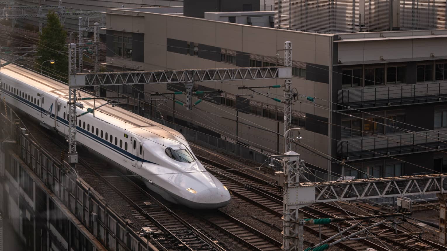 Shinkansen bullet train arrives at the station at sunset