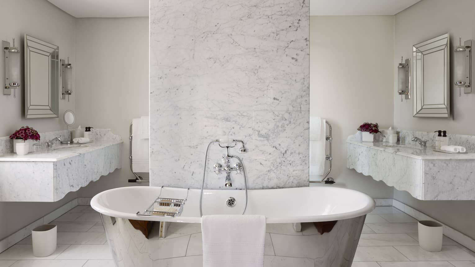 Luxury hotel suite bathroom with standalone tub and two marble vanities at Four Seasons Hotel Johannesburg