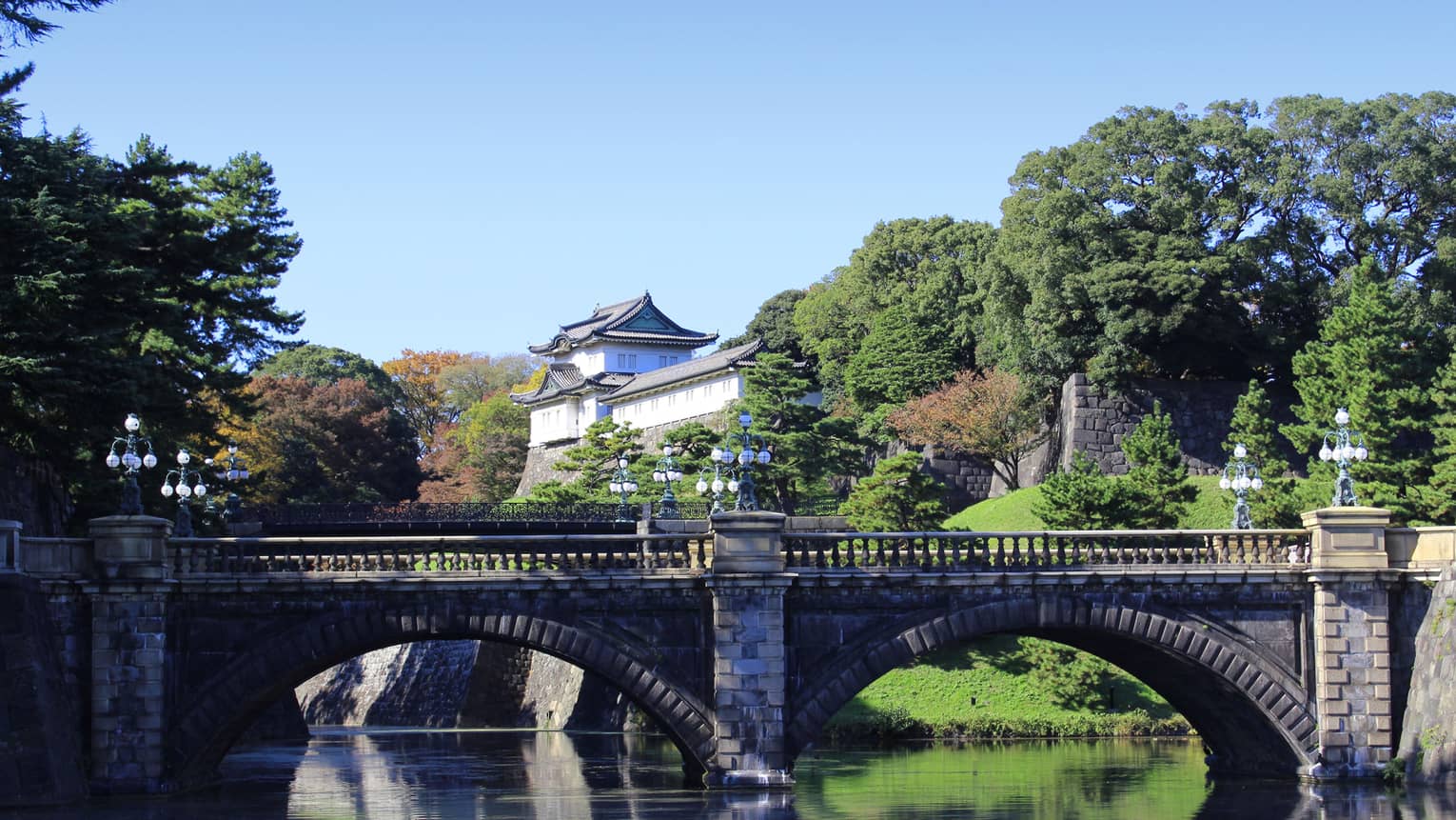 Nijubashi stone bridges over moat by house, sunny garden