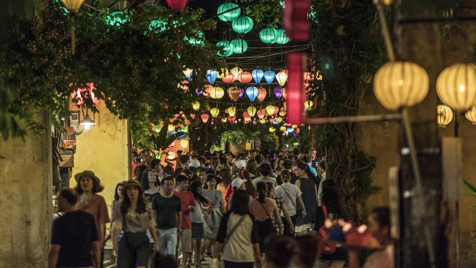 A nighttime view of a crowded street at night, lit with colorful lanterns in Hoi, Viet Nam