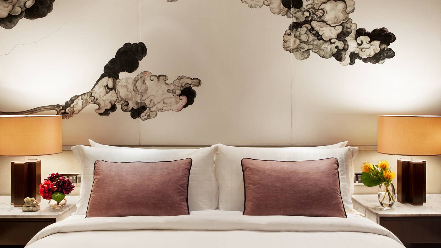 Club Grand Room hotel bed with pink accent pillows under Chinese brushwork mural