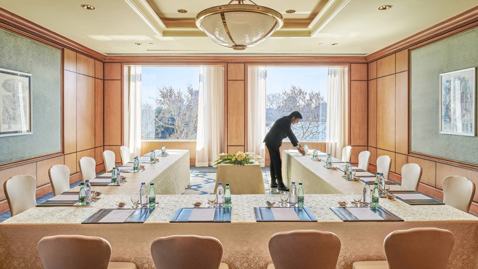 Hotel staff sets modular conference table in sunny Garden City meeting room