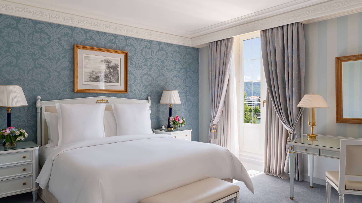 Luxury hotel room with blue wall paper accent wall and king bed at Four Seasons Hotel des Bergues, Geneva