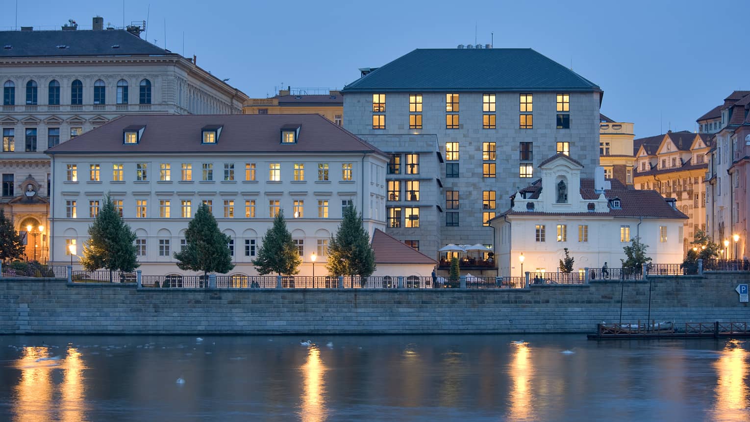 Four Seasons Hotel Prague exterior at night with lit windows, reflecting on Vltava River