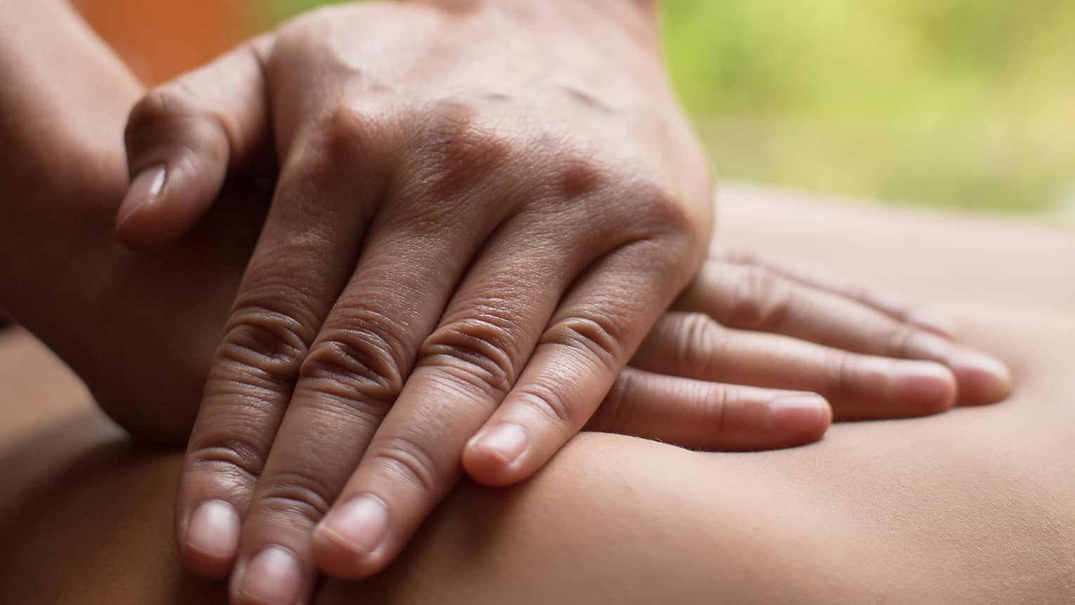 Close up of hands massaging a back