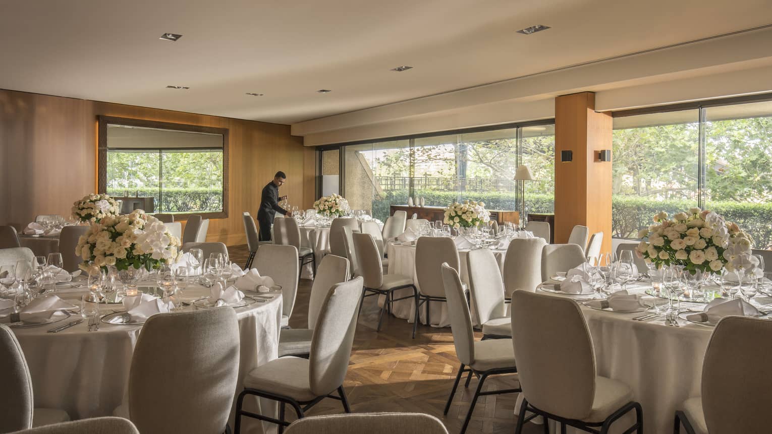 Hotel staff sets round banquet dining tables in event room