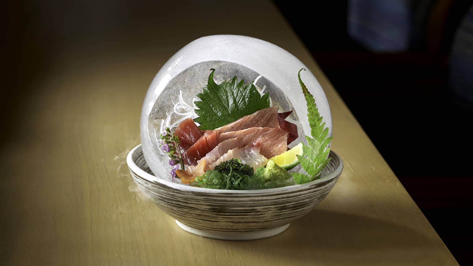 Assorted sashimi with perilla leaves in clear dome
