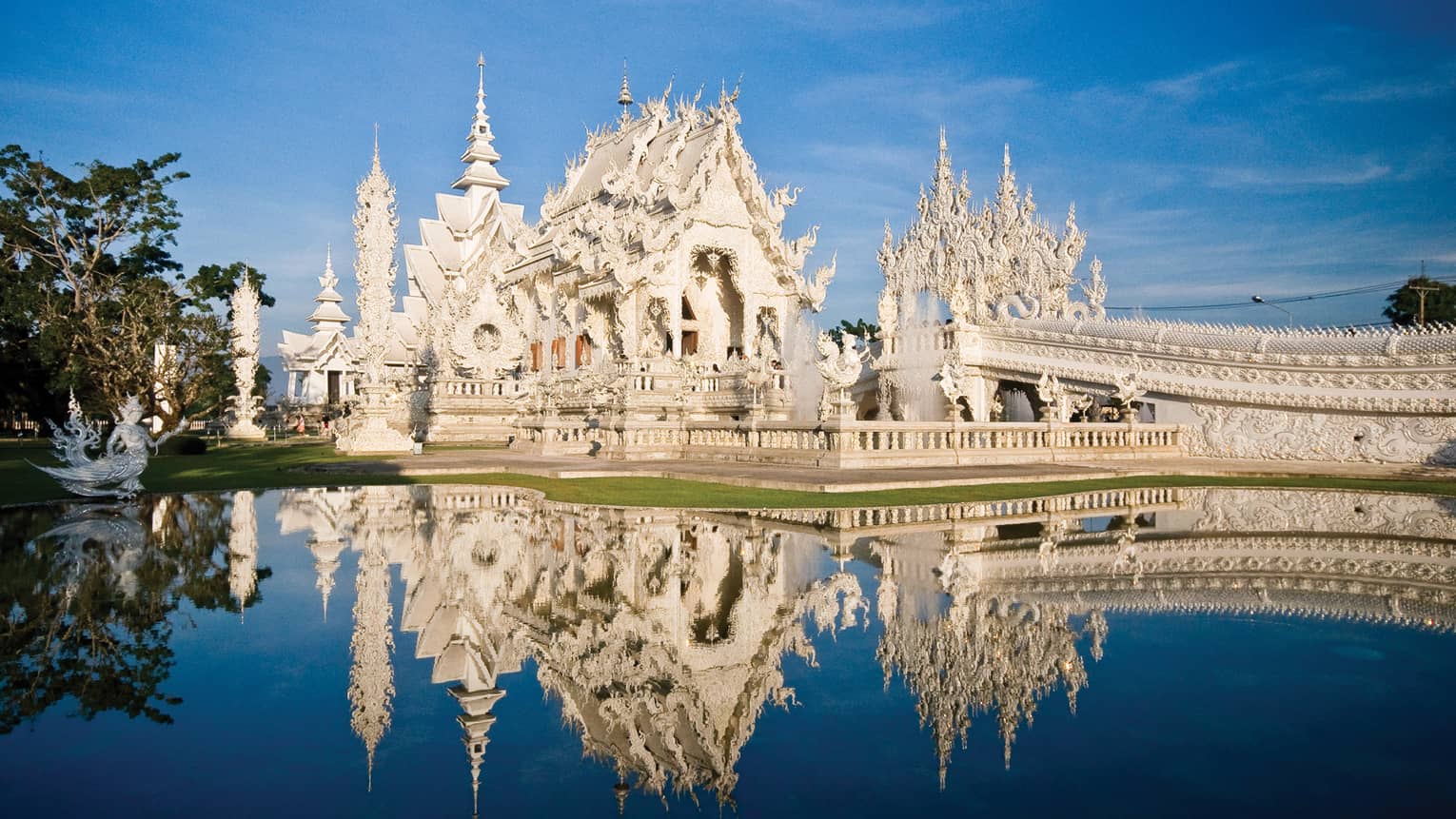 An ornate white castle reflecting in a pond