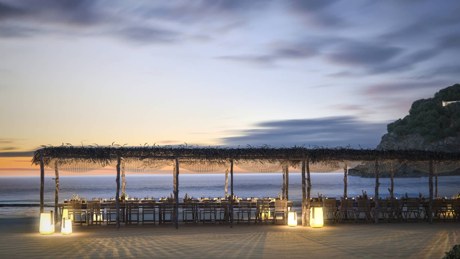 Long table and pergola on the beach, set for private event at dusk