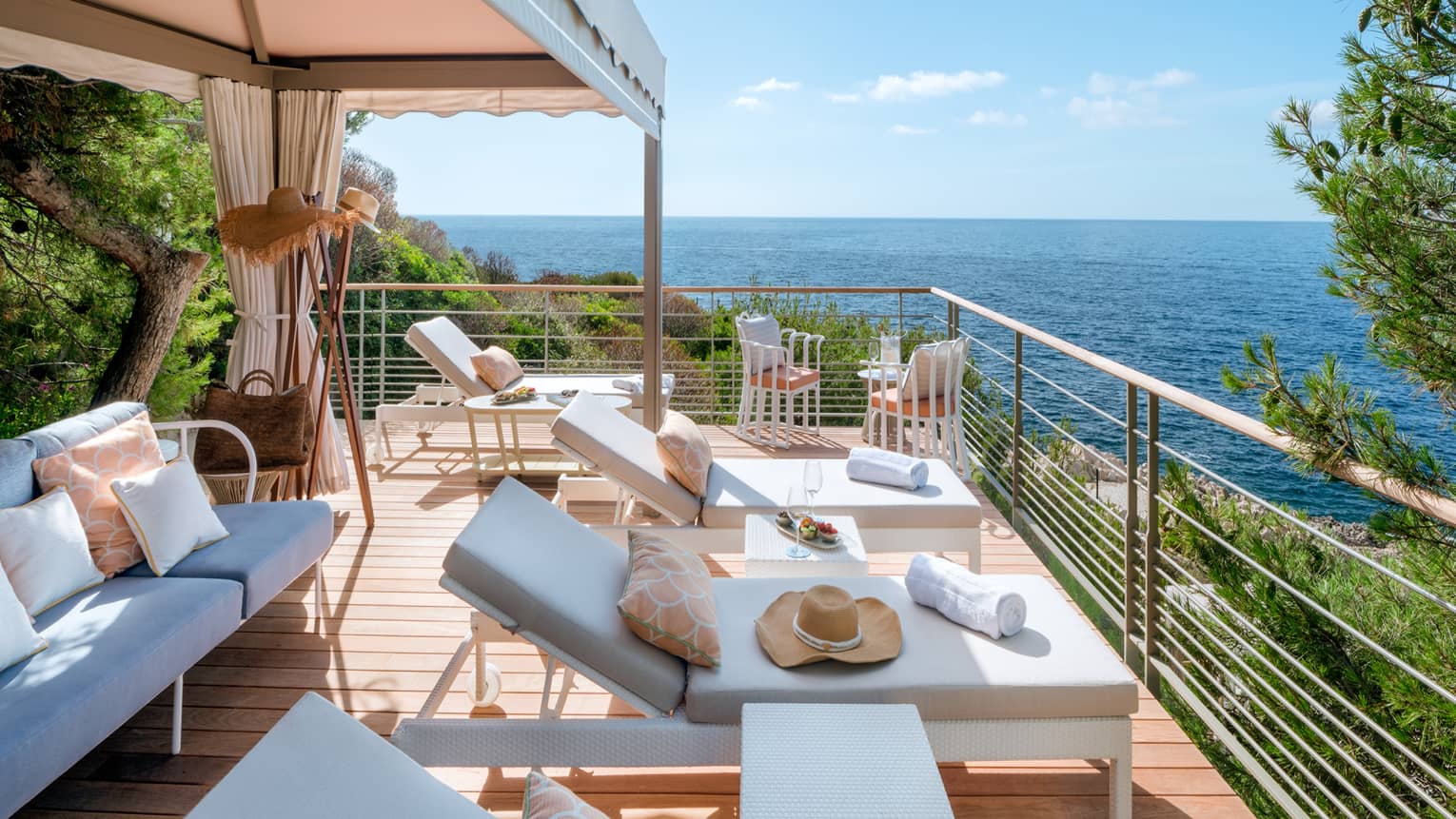 Club Dauphin private cabana terrace with white settee and lounge chairs, sea view