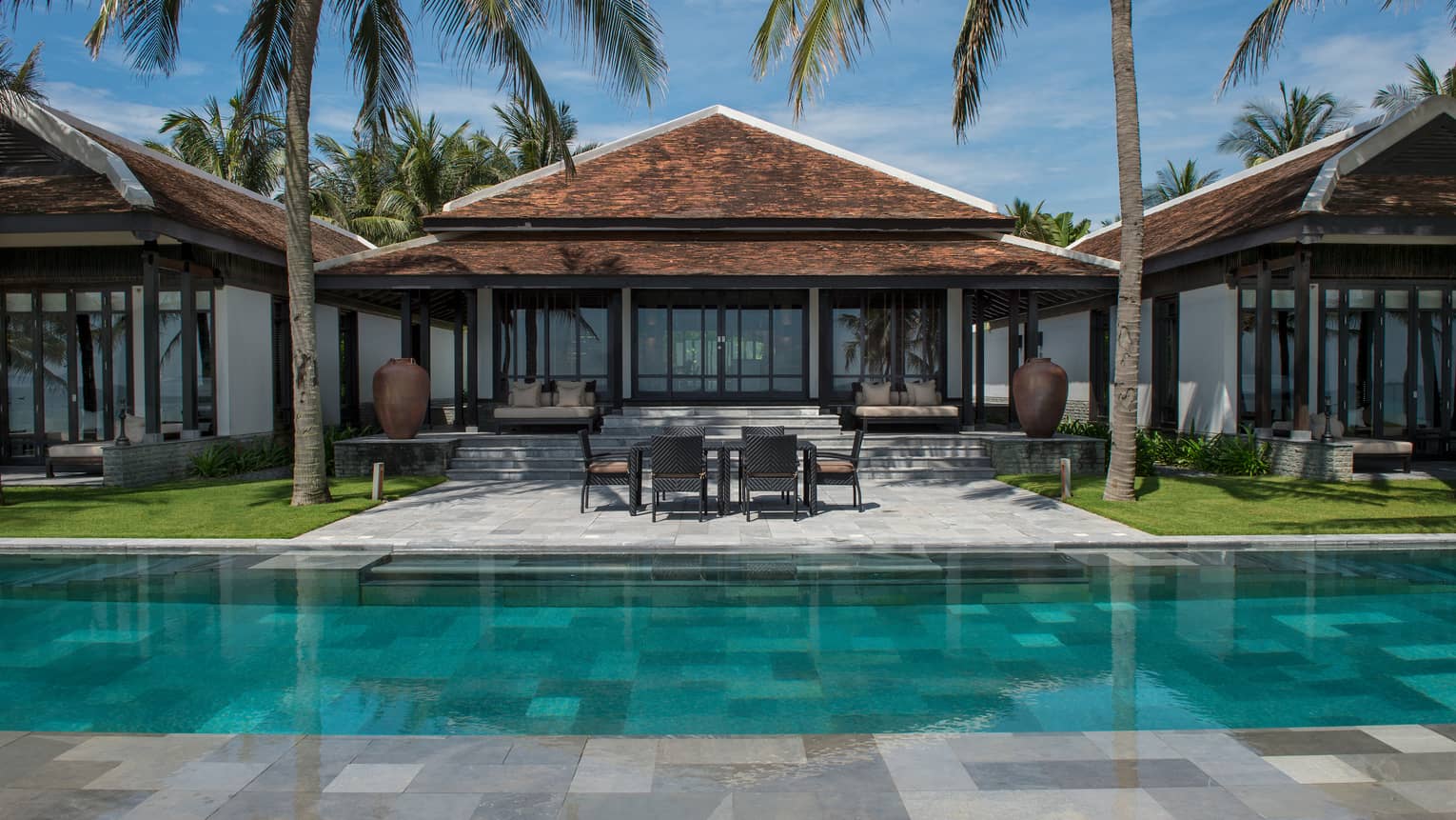 View of Ocean View Pool Villa exterior, patio under palms, from outdoor pool