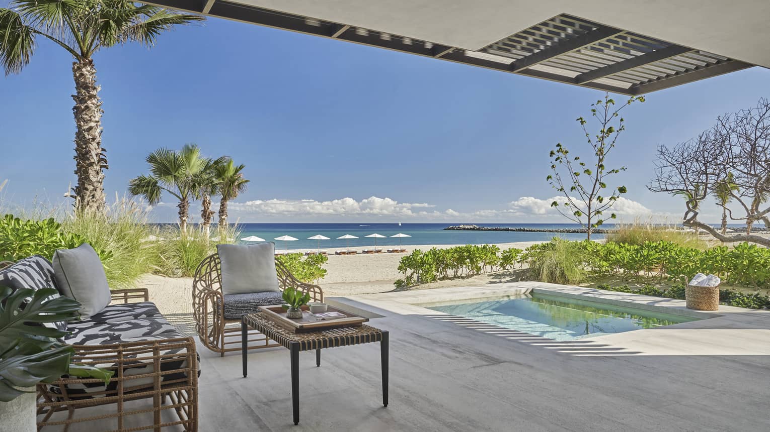Outdoor terrace with beach and ocean view, small pool, two arm chairs and table