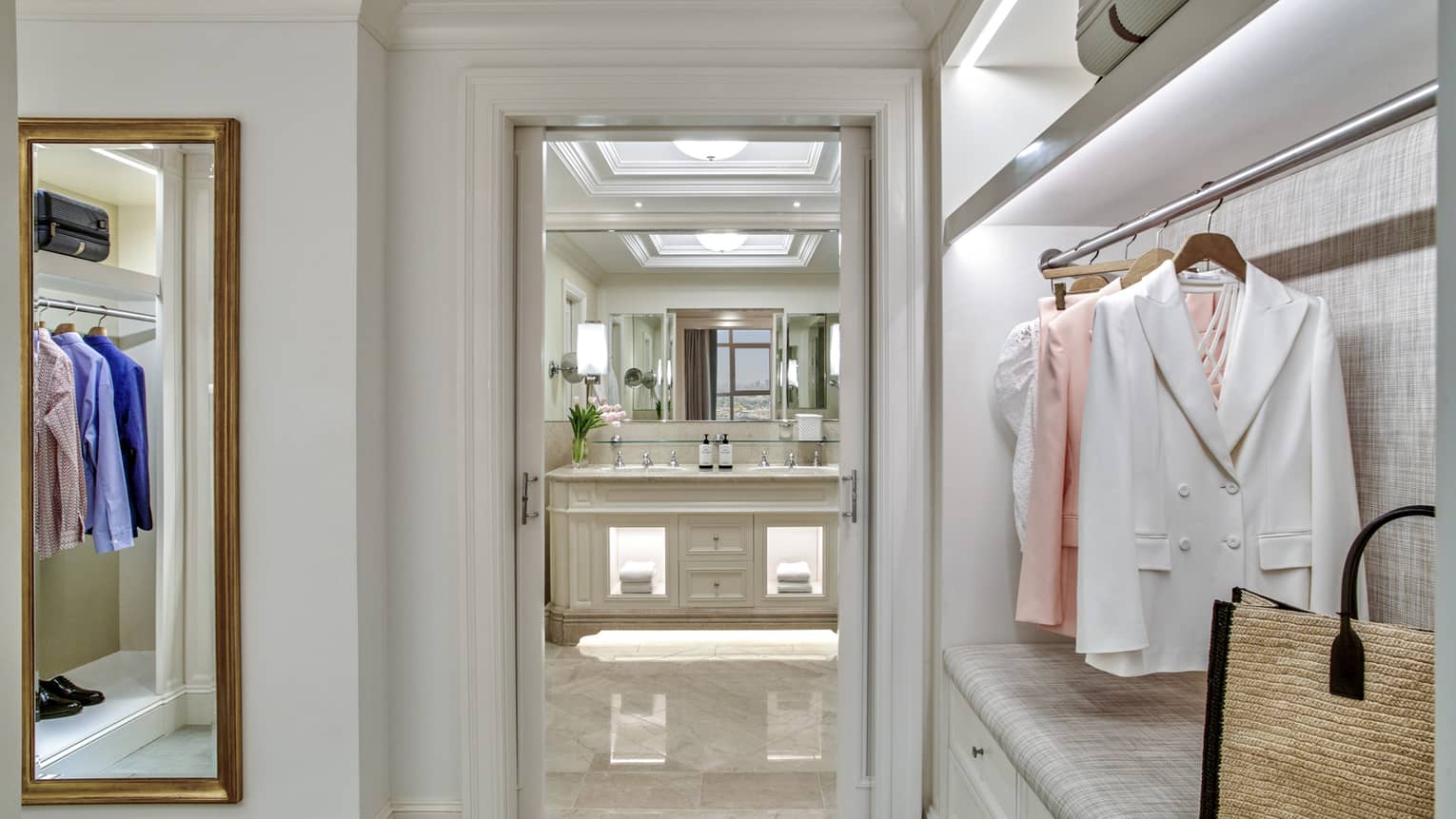 Guest room walk-in closet with full-length mirror, doorway to bathroom