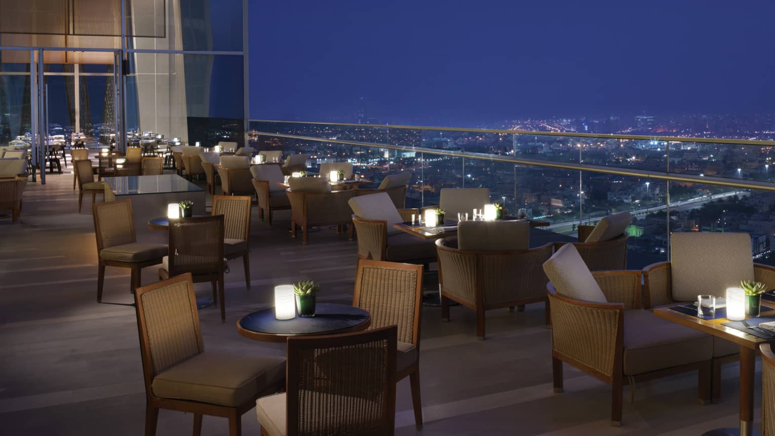 Several small chairs set up on an outdoor terrace overlooking the cityscape of Dubai.
