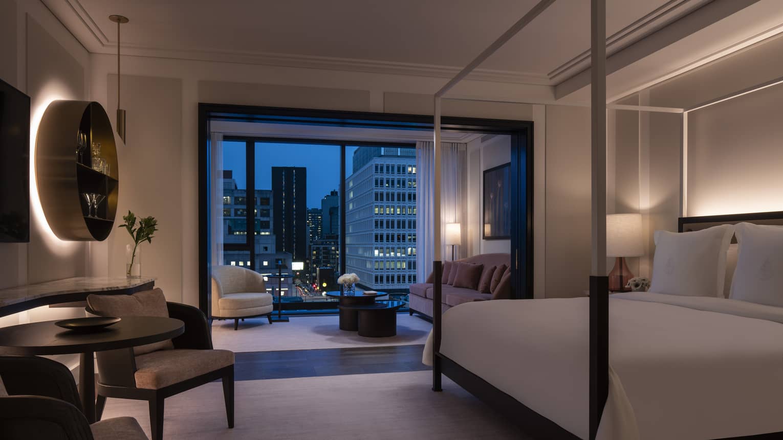 Four Seasons Executive Suite, dimly lit with four-poster modern bed and evening patio views