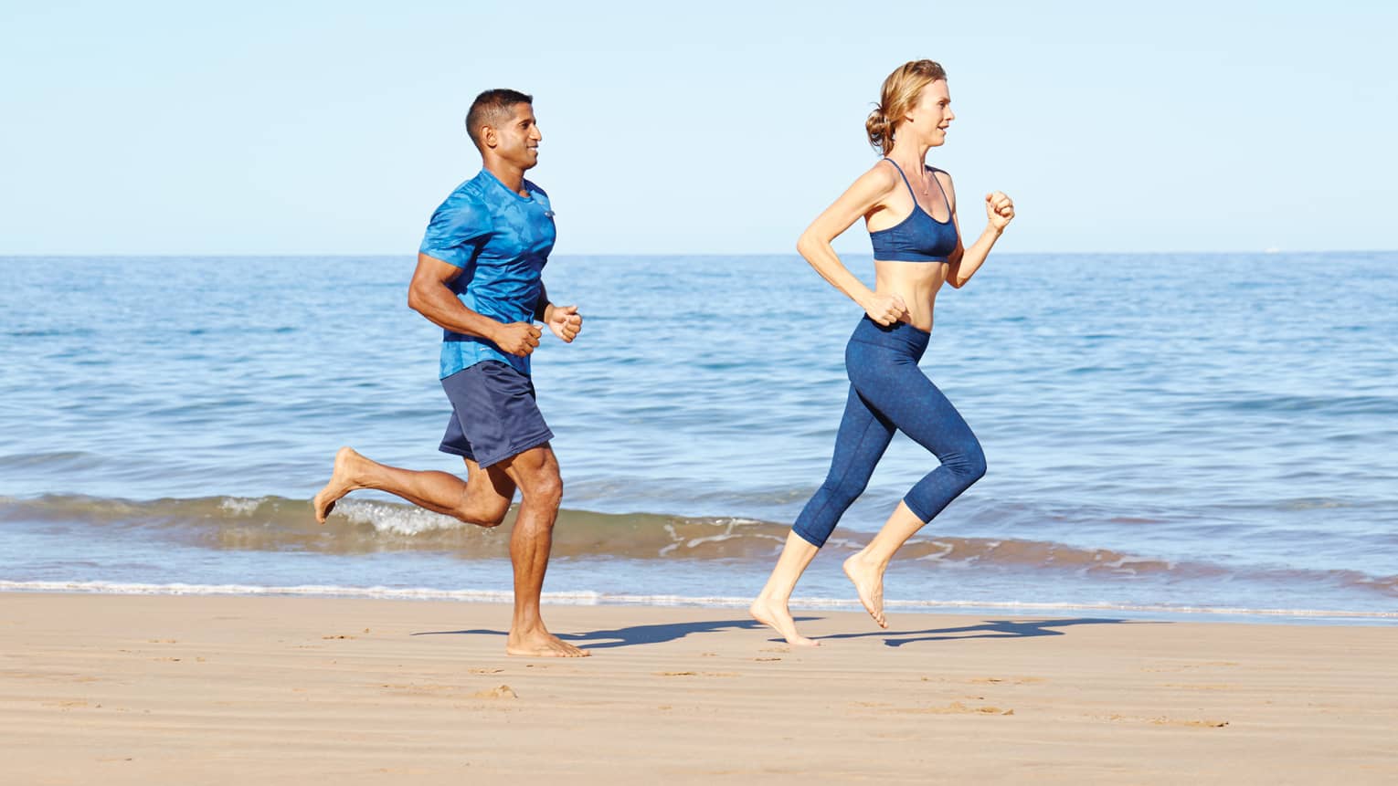 Man and woman run on beach