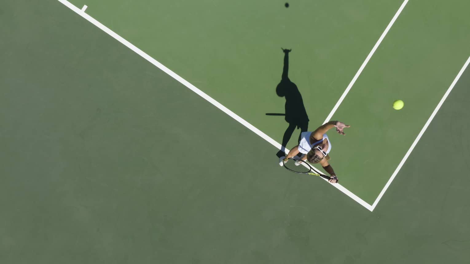 Aerial view of a tennis player mid serve