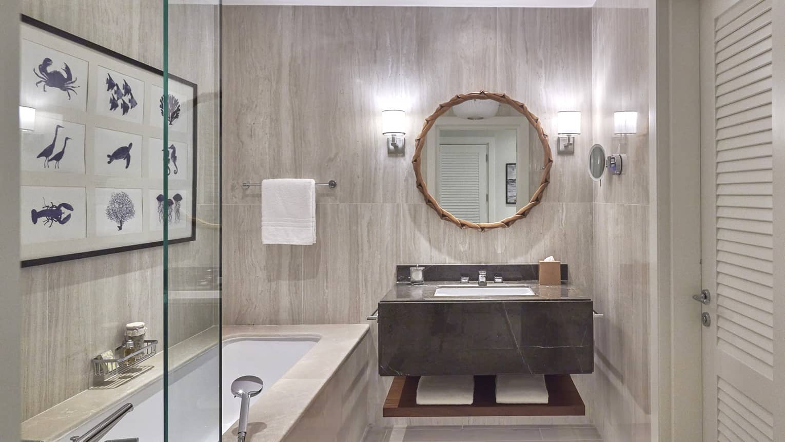Bathroom with tub, vanity and circular mirror