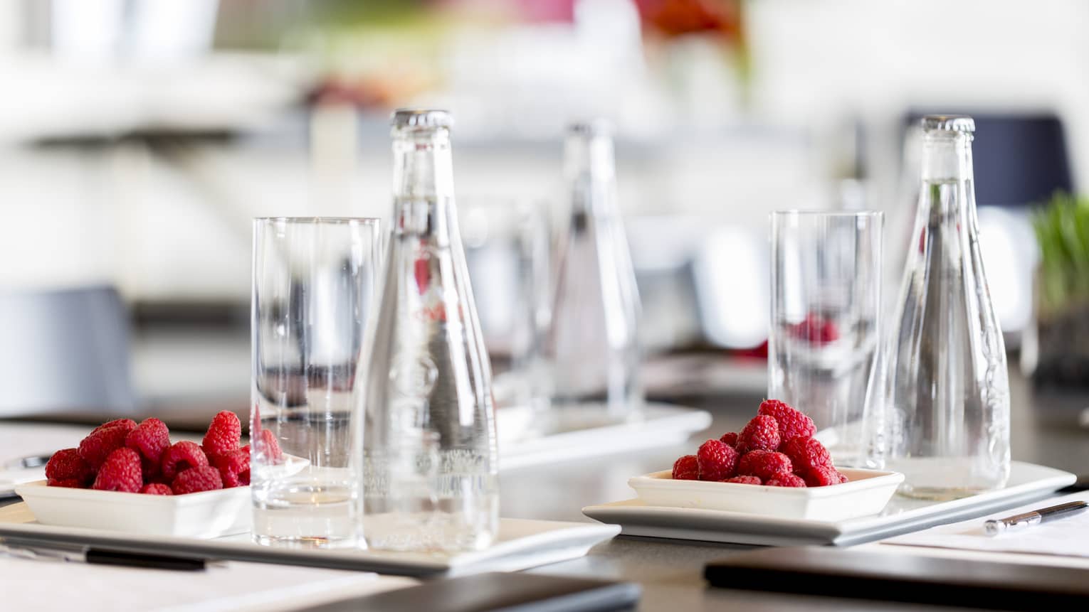 A detail from a meeting – clear glasses and red raspberries on a dark wooden table at Four Seasons Atlanta