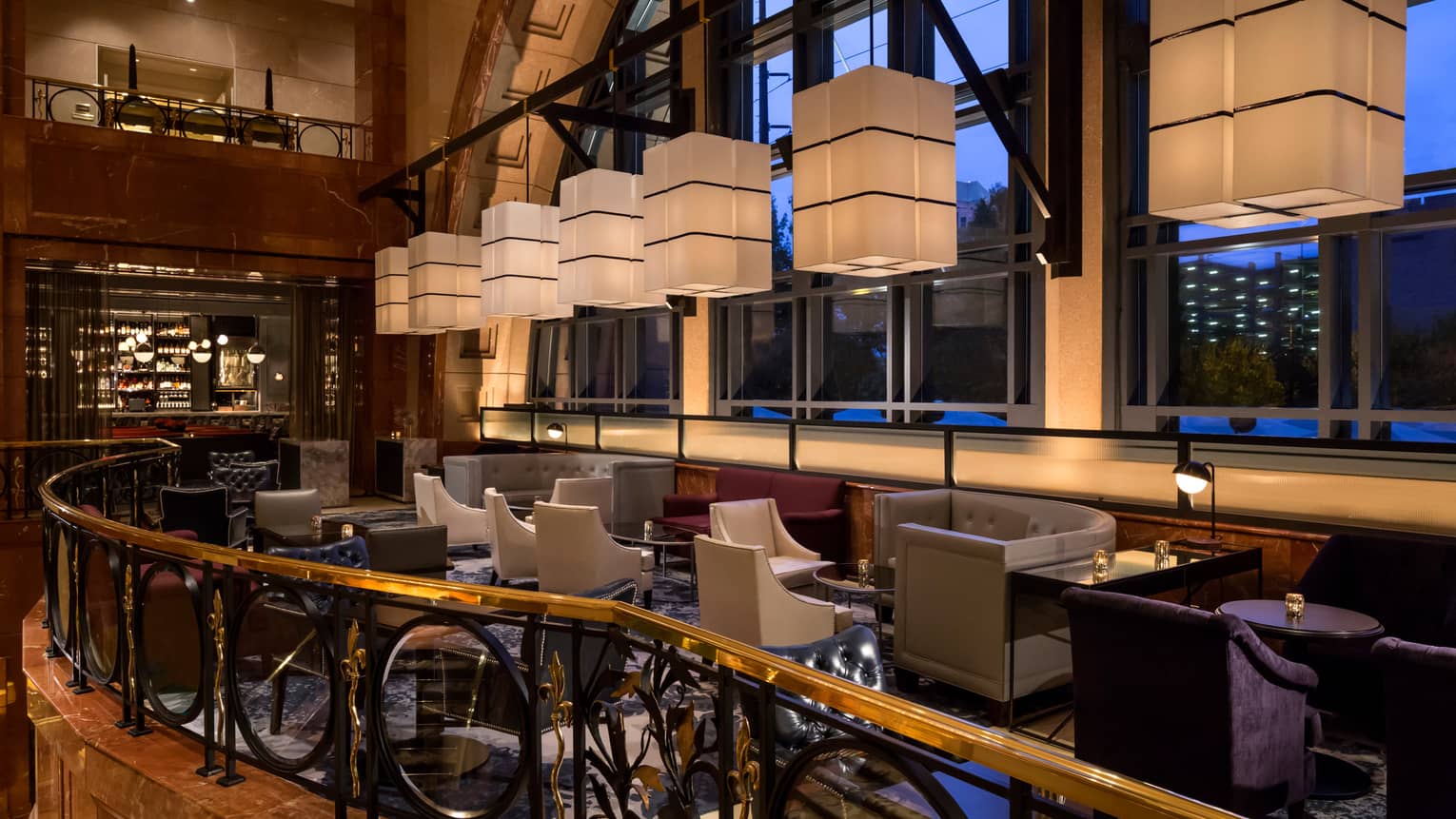White rectangular lanterns hang above Bar Margot lounge area in front of arched window