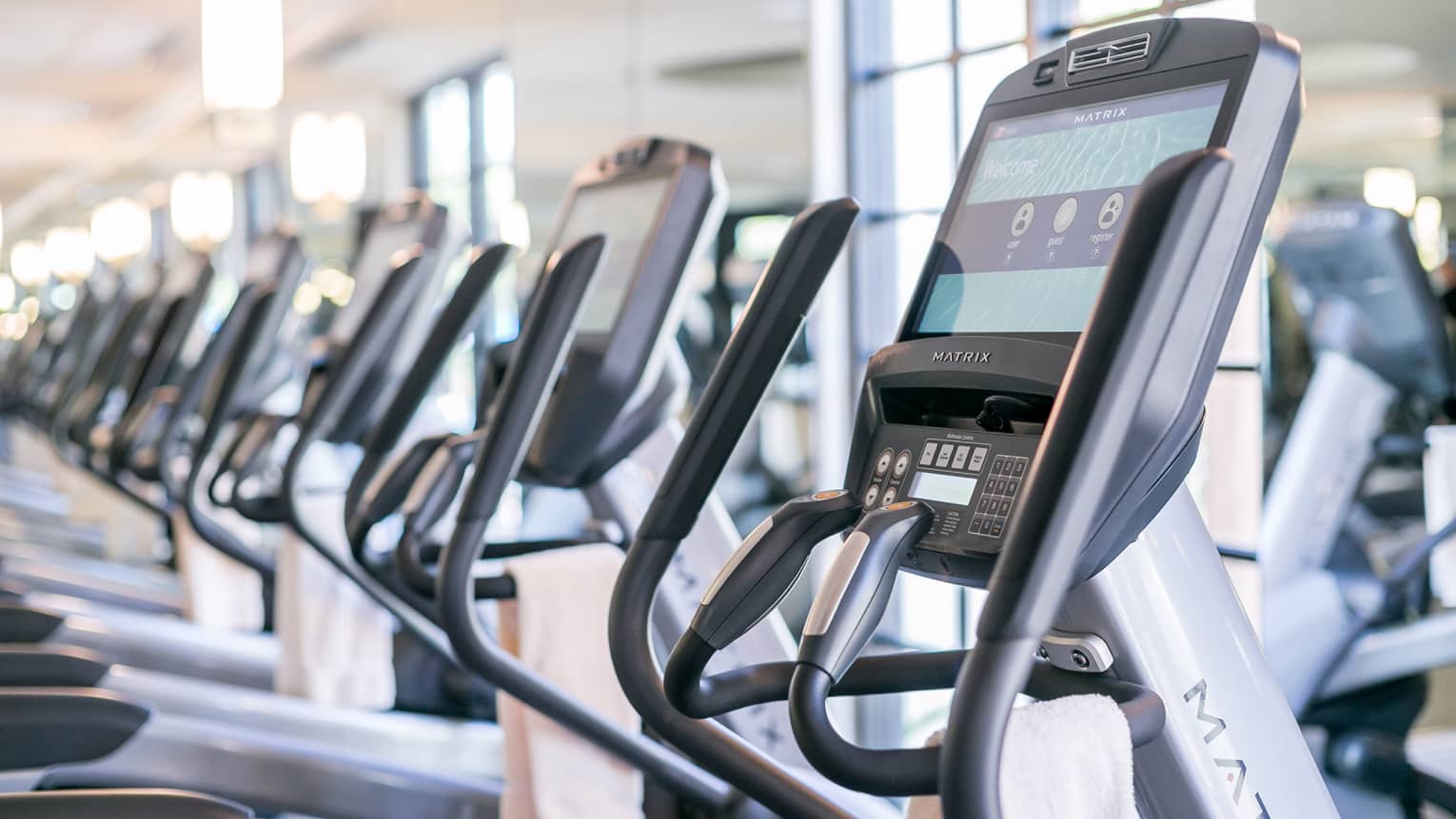 Close-up of cardio elliptical machines in a row in fitness facility