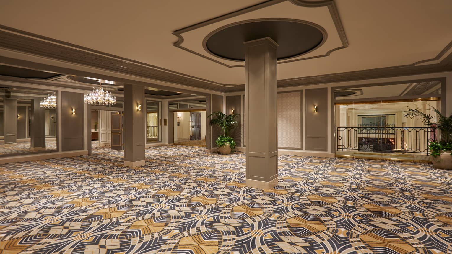 Pillar in middle of large, empty, carpeted Le Petit Trianon ballroom 